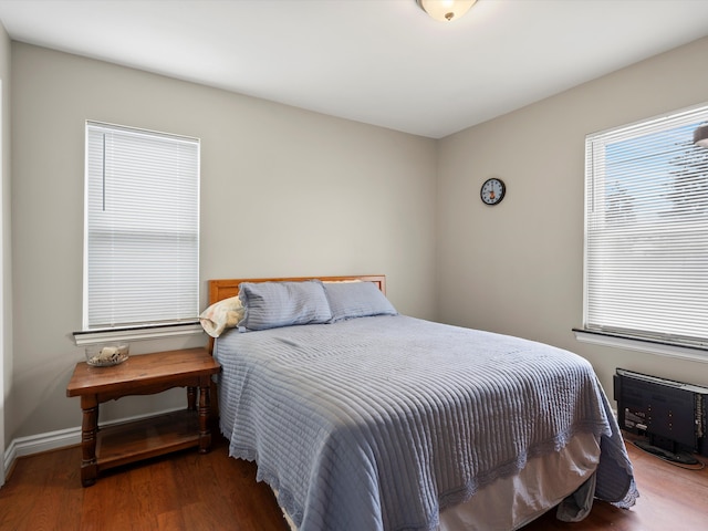 bedroom with baseboards and dark wood finished floors