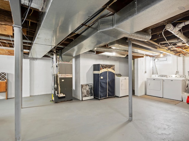 below grade area featuring heating unit and washer and clothes dryer