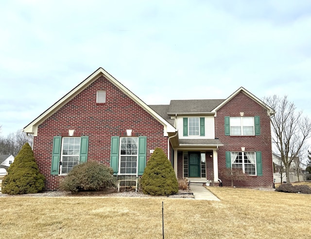 view of front of house with a front yard and brick siding