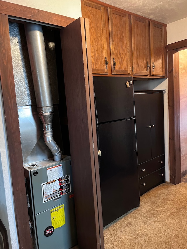 interior space with freestanding refrigerator, brown cabinets, and light carpet