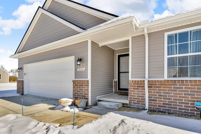 exterior space with a garage, driveway, and brick siding