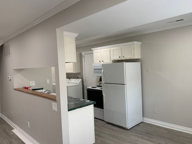 kitchen featuring white cabinetry, separate washer and dryer, wood-type flooring, ornamental molding, and white appliances