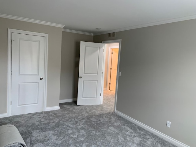 unfurnished bedroom with crown molding and dark colored carpet