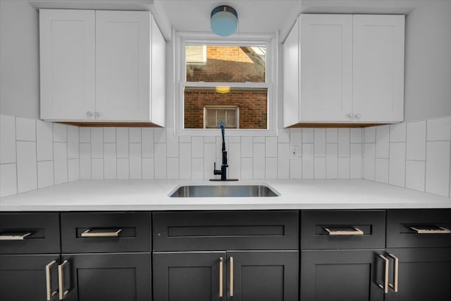 kitchen featuring white cabinetry, sink, and decorative backsplash