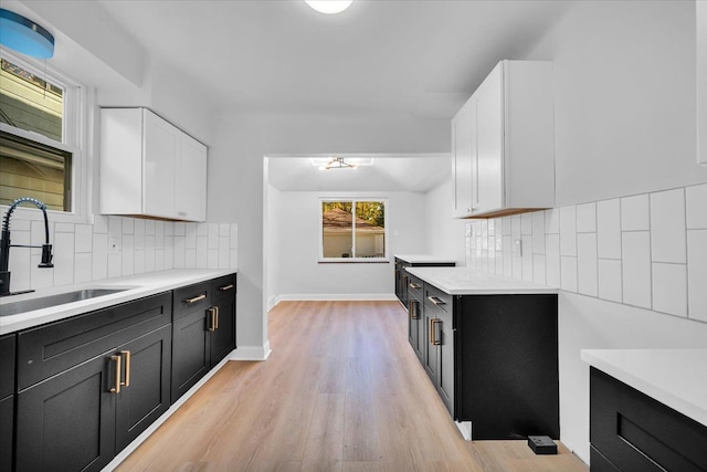 kitchen featuring tasteful backsplash, sink, and white cabinets