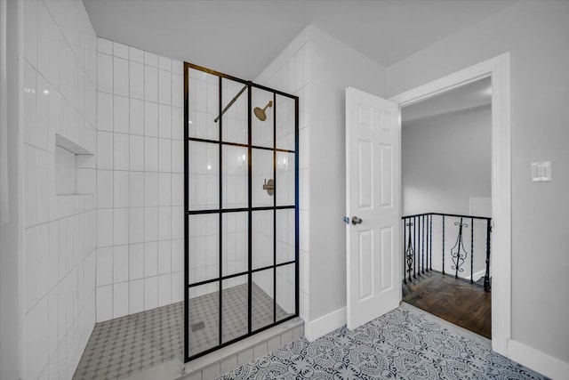 bathroom featuring tiled shower and tile patterned flooring