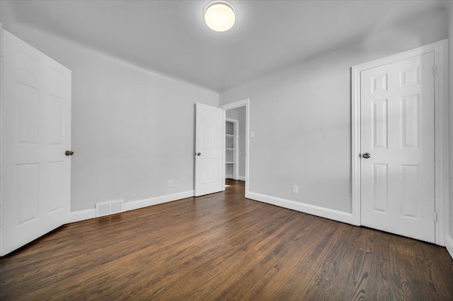 unfurnished bedroom featuring dark wood-type flooring