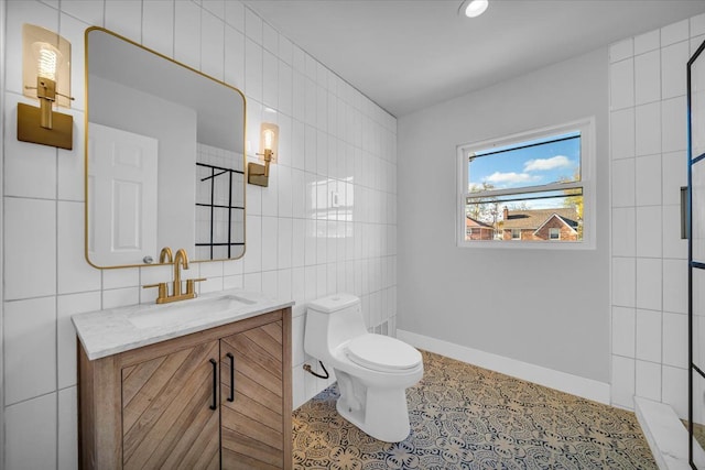 bathroom featuring tile patterned flooring, vanity, tile walls, and toilet