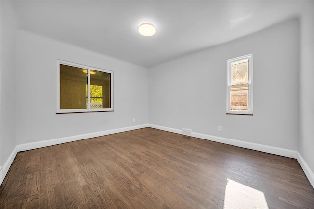 spare room with a healthy amount of sunlight and hardwood / wood-style floors