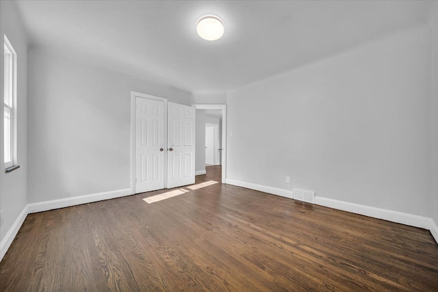 unfurnished room featuring dark wood-type flooring