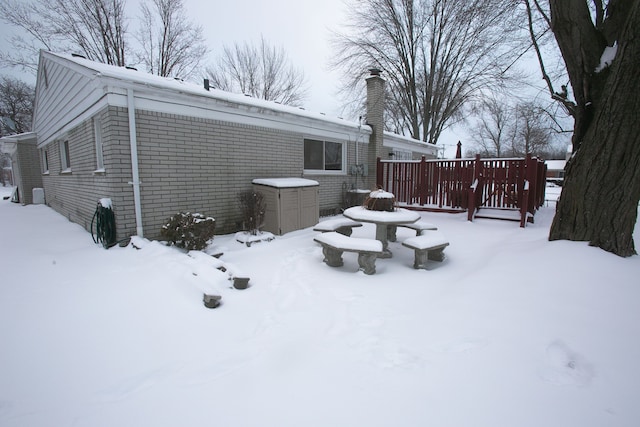 exterior space featuring a chimney and brick siding