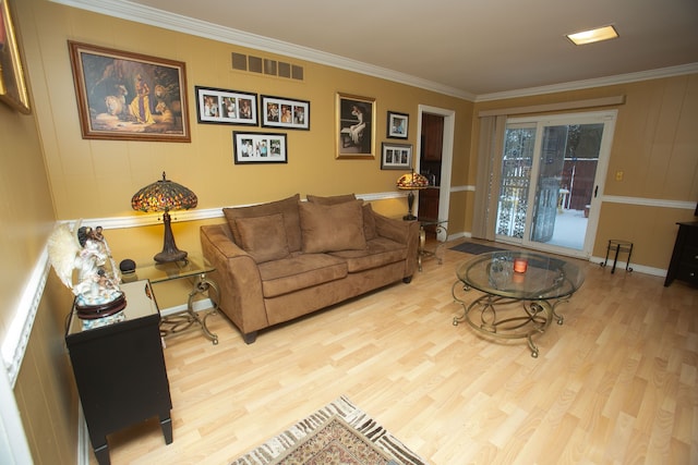 living room with light wood-type flooring, visible vents, crown molding, and baseboards