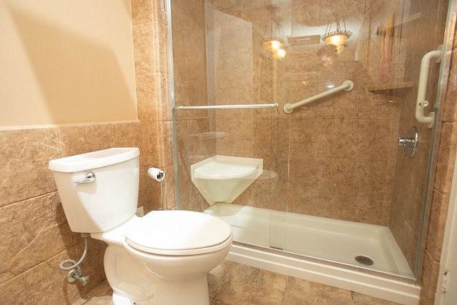 full bathroom featuring a stall shower, toilet, and tile walls