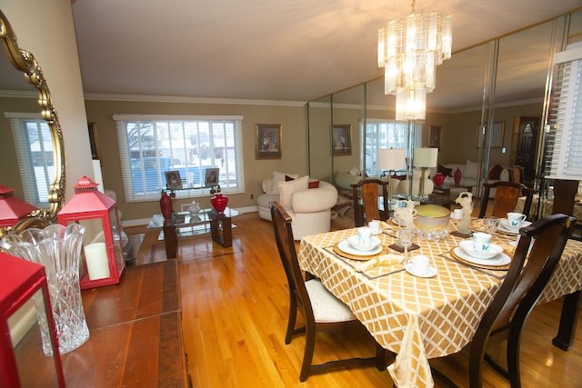 dining space with an inviting chandelier, baseboards, crown molding, and wood finished floors