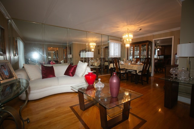 living area with crown molding, a chandelier, and wood finished floors