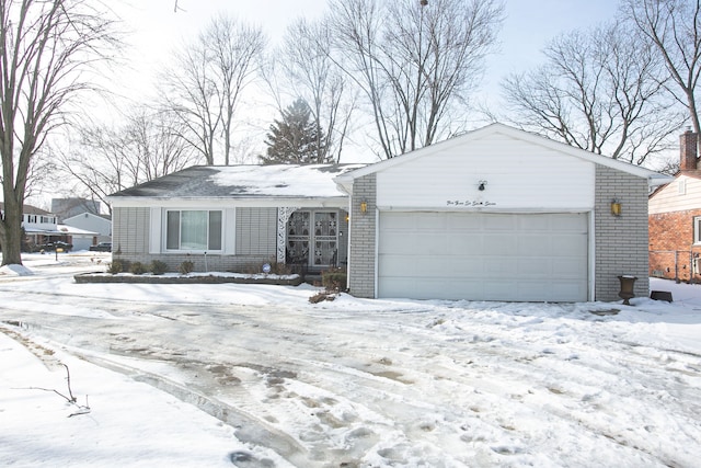 single story home with a garage and brick siding