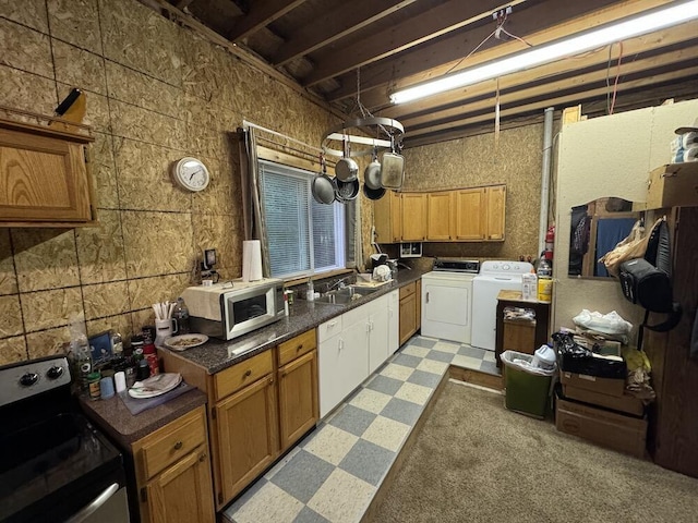 kitchen with appliances with stainless steel finishes, sink, and independent washer and dryer