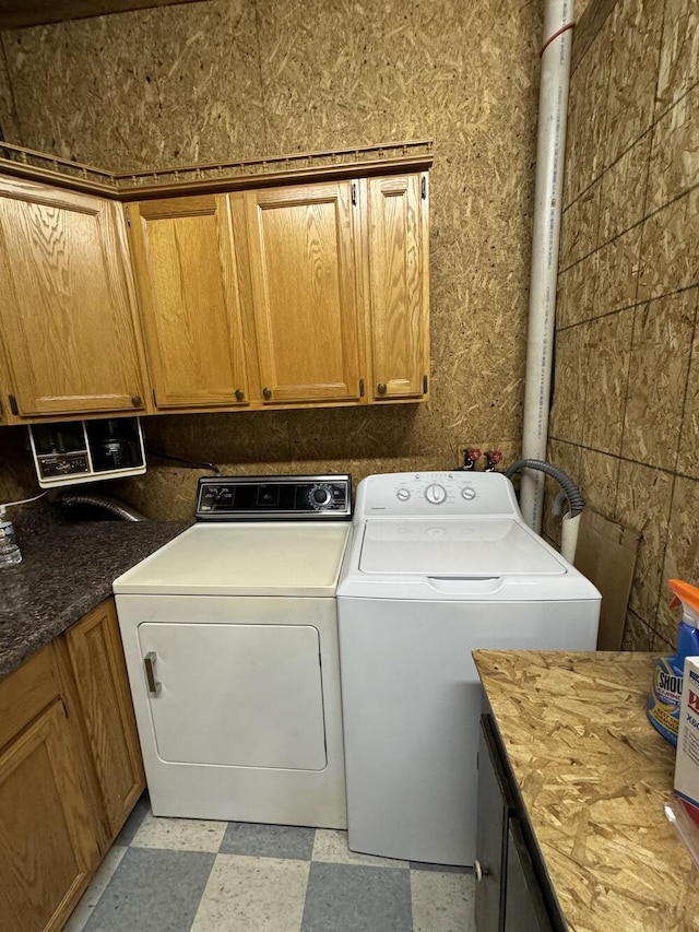 clothes washing area with cabinets and independent washer and dryer