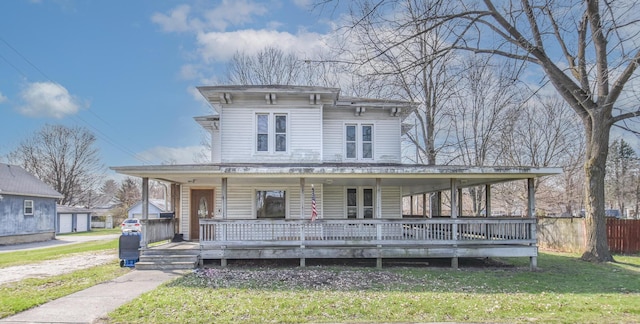 italianate house featuring a front lawn, covered porch, and fence