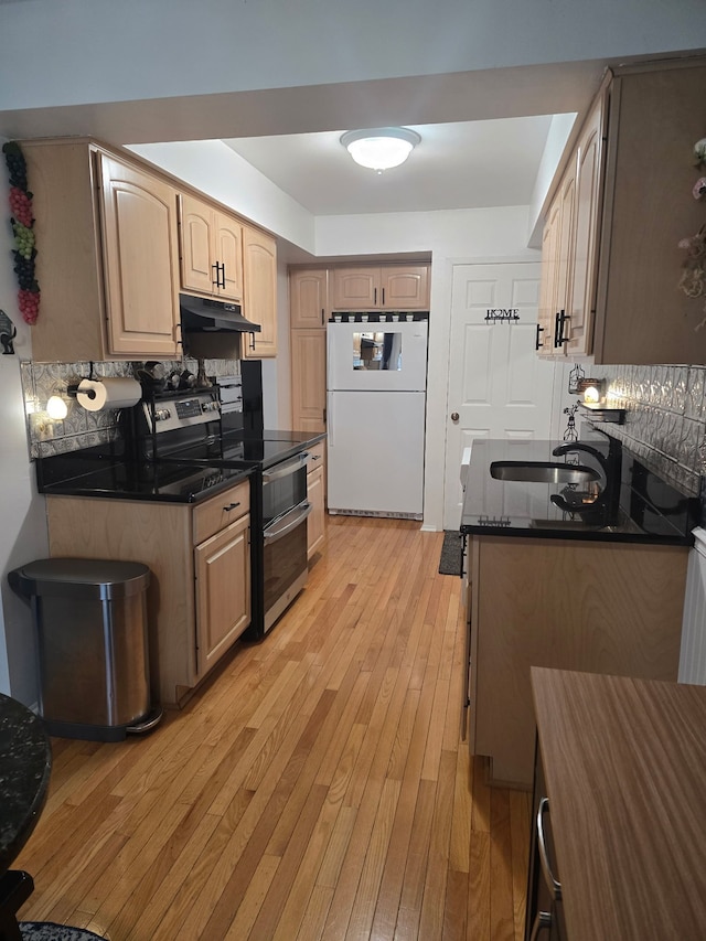 kitchen with sink, backsplash, range with two ovens, white fridge, and light hardwood / wood-style flooring