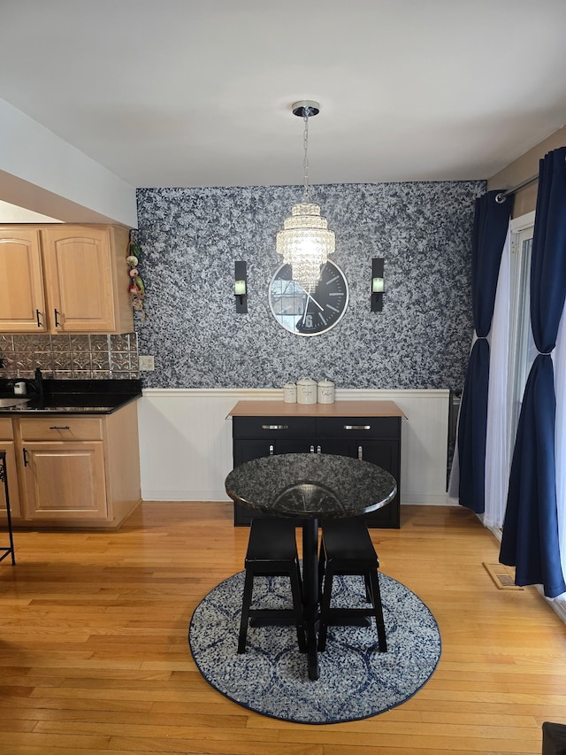 dining area featuring light hardwood / wood-style flooring and a chandelier