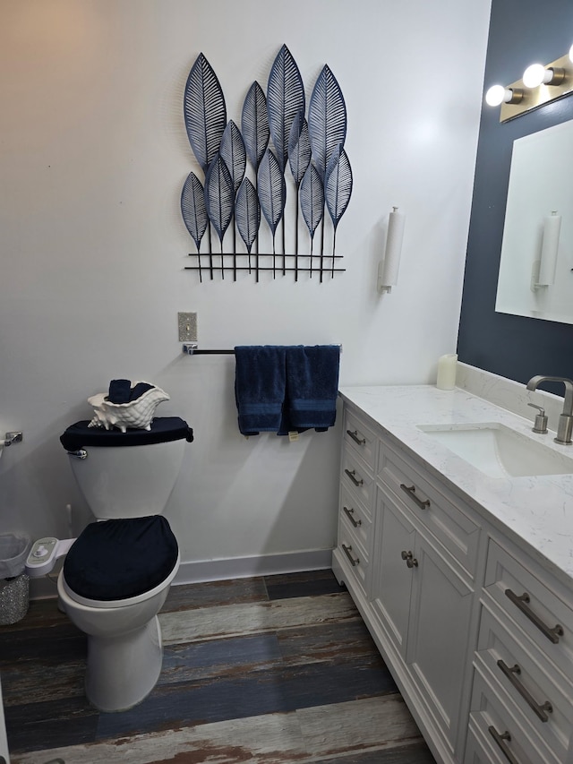 bathroom with hardwood / wood-style flooring, vanity, and toilet