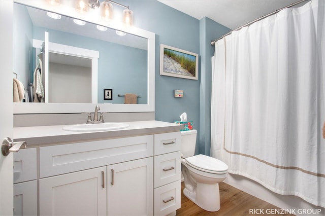 bathroom with vanity, hardwood / wood-style floors, curtained shower, and toilet