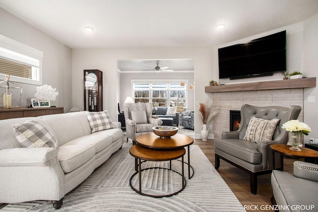 living room with ceiling fan, hardwood / wood-style floors, and a fireplace