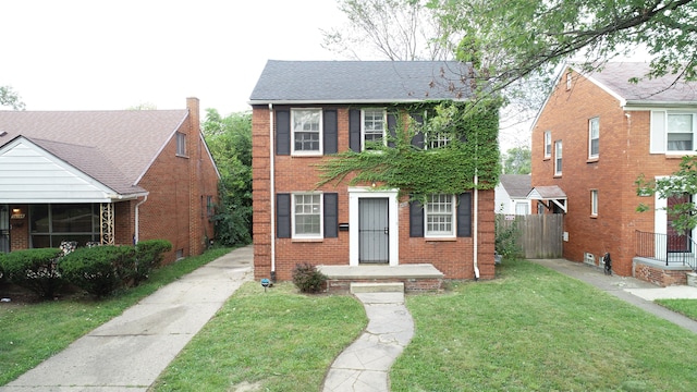 view of front of home featuring fence, a front lawn, and brick siding