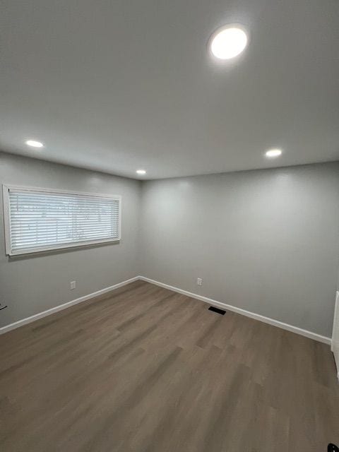 empty room with dark hardwood / wood-style flooring