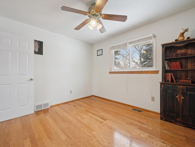 empty room with ceiling fan and light hardwood / wood-style flooring