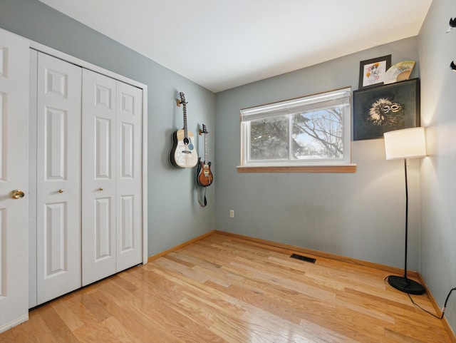 unfurnished bedroom with light hardwood / wood-style floors and a closet