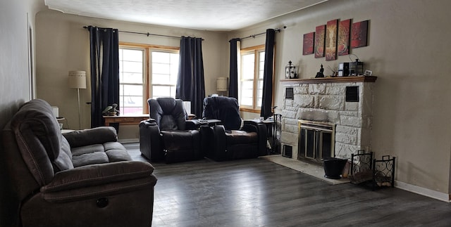 living room with a fireplace and dark wood-type flooring