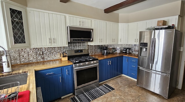 kitchen featuring blue cabinetry, wooden counters, appliances with stainless steel finishes, white cabinets, and backsplash