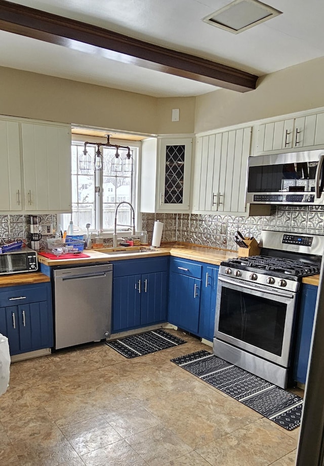 kitchen featuring sink, backsplash, stainless steel appliances, and blue cabinetry