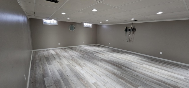 basement with a paneled ceiling and light wood-type flooring