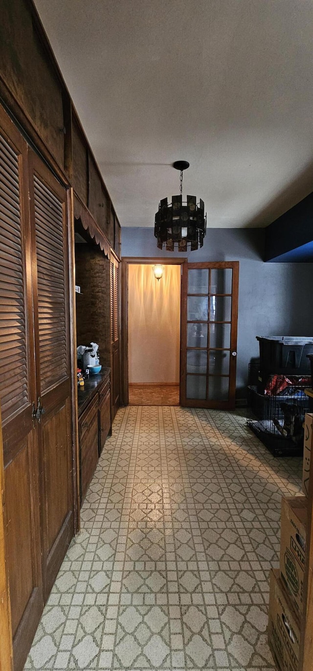 mudroom with a notable chandelier and a textured ceiling