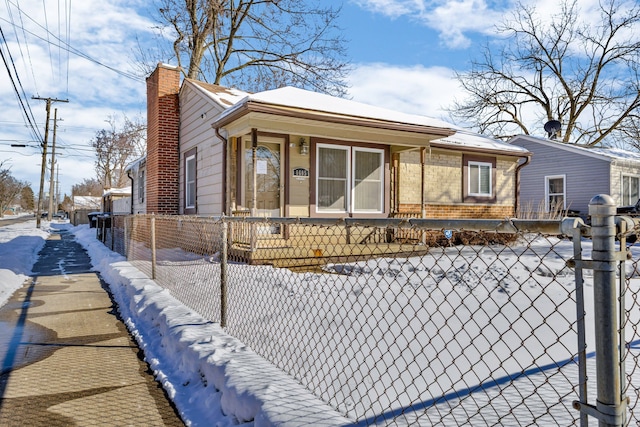 view of front of house featuring a fenced front yard, a chimney, and brick siding