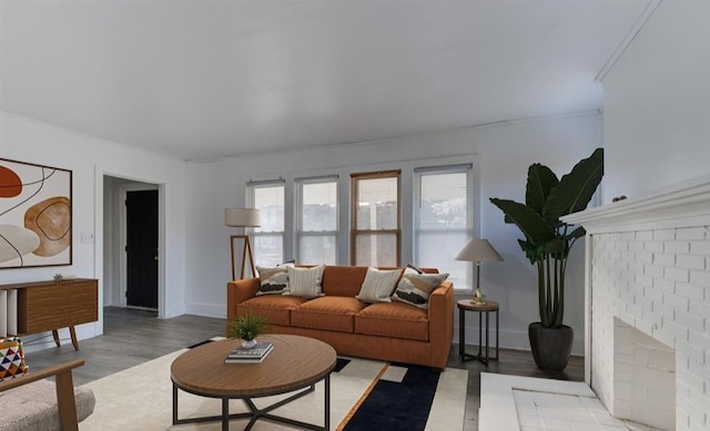 living room featuring a brick fireplace and light wood-type flooring