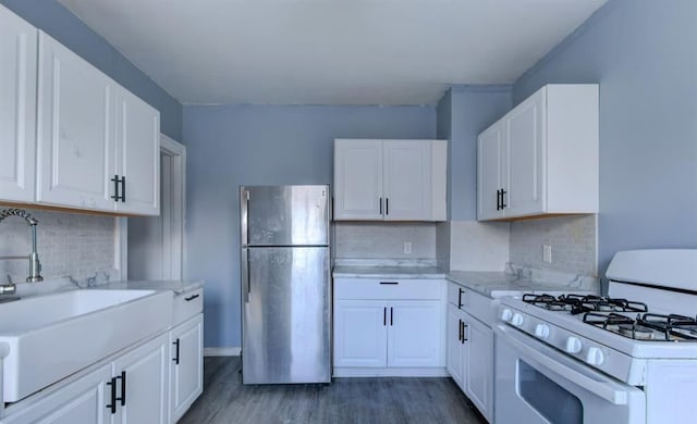 kitchen featuring white cabinetry, white gas range, and stainless steel refrigerator