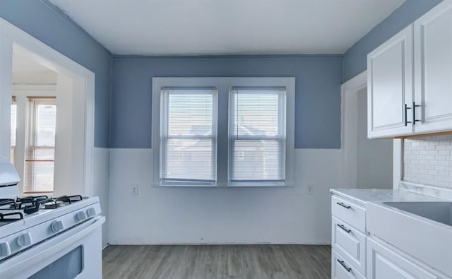 kitchen featuring white cabinetry, sink, white range with gas cooktop, and light hardwood / wood-style floors