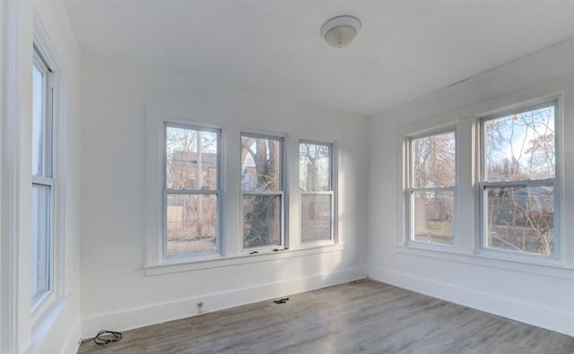 empty room featuring hardwood / wood-style floors and plenty of natural light