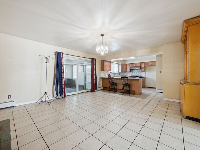 unfurnished living room with a baseboard radiator, light tile patterned flooring, and an inviting chandelier