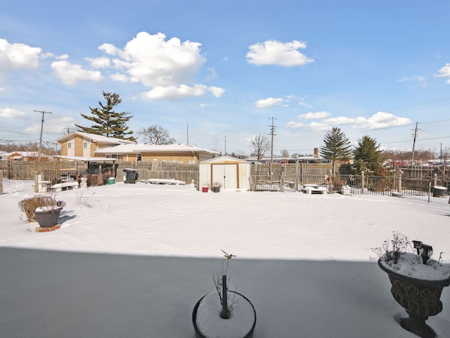 yard layered in snow with a shed