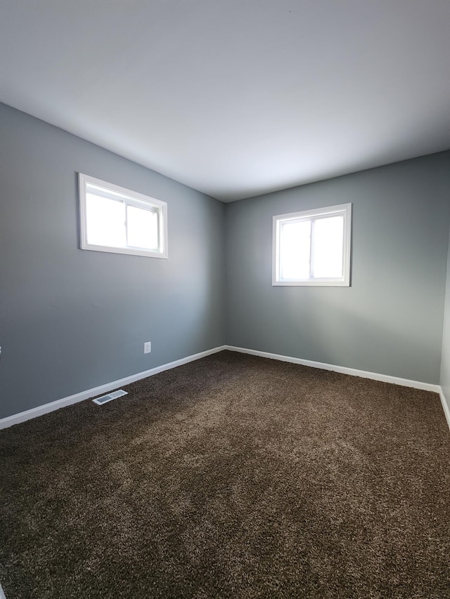 carpeted empty room with plenty of natural light