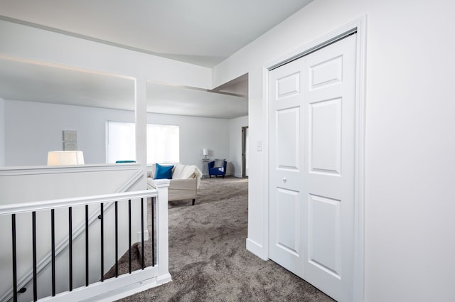 corridor featuring carpet, an upstairs landing, and baseboards