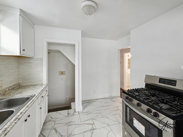 9941 Minock St, Detroit, MI 48228 - kitchen featuring stainless steel gas stove, backsplash, white cabinetry, and sink