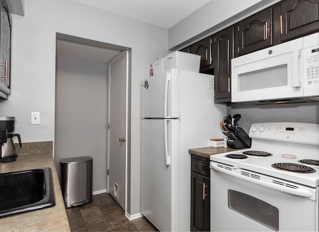 kitchen featuring white appliances, dark brown cabinetry, and sink