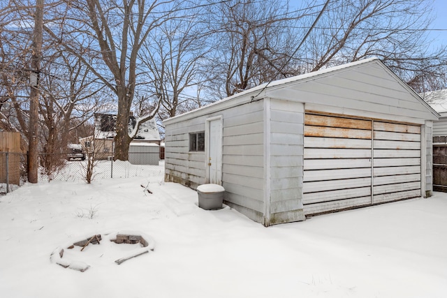 snow covered structure featuring a garage