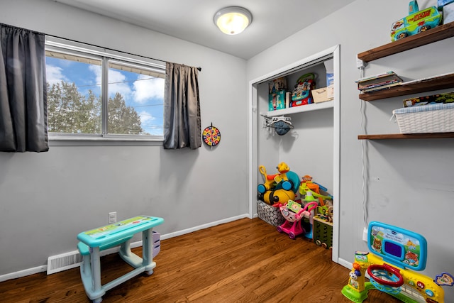 playroom featuring visible vents, baseboards, and wood finished floors